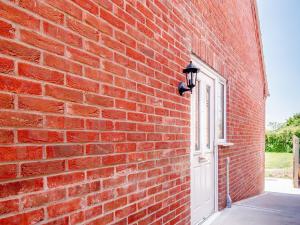 a brick wall with a white door and a window at Dawson Park 8 - Uk12667 in Mablethorpe