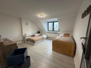 a attic bedroom with two beds and a window at Schorrebloem in Lombardsijde