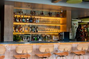 a bar with wooden chairs and a christmas tree at Liwe Hotels in Penha