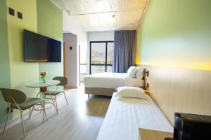 a hotel room with two beds and a table at Liwe Hotels in Penha