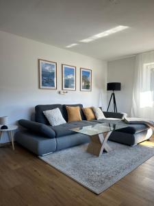 a living room with a blue couch and a glass table at Ferienwohnung Bergidyll in Schönau am Königssee