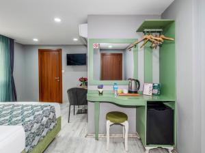 a bedroom with a green desk and a bed at Green Garden Hotel - Bahçelievler in Istanbul