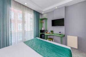 a bedroom with a large bed and a desk at Green Garden Hotel - Bahçelievler in Istanbul