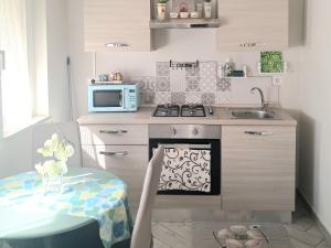 a small kitchen with a stove and a sink at La Rosa Verde in Castrovillari
