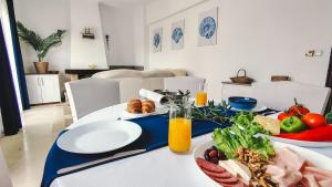 a table with plates of food and a bowl of fruit at Blue Pearl Molos in Mólos