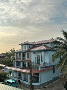 a large house with a balcony and a palm tree at Memory Homestay Ông Chung in Lệ Thủy +19 photos