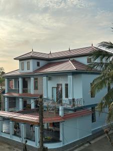 a large white house with a large deck at Memory Homestay Ông Chung in Lệ Thủy