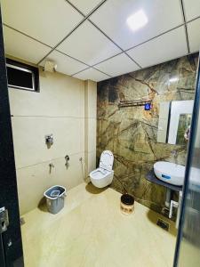 a bathroom with a toilet and a sink at Hotel Hunter in Bārdoli