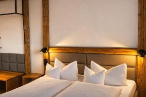 ein Hotelzimmer mit einem Bett mit weißen Kissen in der Unterkunft Hotel Grüner Baum in Würzburg