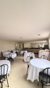 a dining room with white tables and chairs at Imbau Palace Hotel in Imbau