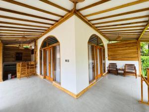 an outdoor patio with a wooden ceiling and windows at The Lauk private in Gili Islands