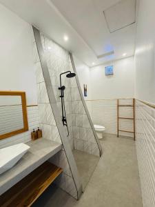 a bathroom with a shower and a sink and a toilet at The Lauk private in Gili Islands +49 photos