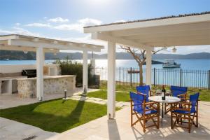 a patio with a table and chairs under a pavilion at Bluevera seafront villa-Aidipsos bay in Gialtra