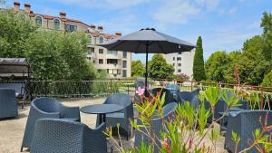a patio with a table and chairs and an umbrella at Rooms Koblar in Portorož