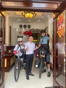 three people are posing for a picture with their bikes at Memory Homestay Ông Chung in Lệ Thủy