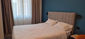 a bed with white sheets and pillows in a bedroom at Hotel V7 in Milan