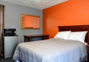 1 dormitorio con 1 cama con pared de color naranja en Redfox Motel en Foxborough