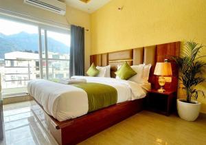 a bedroom with a large bed with a large window at Hotel Blue Moon in Rishīkesh +38 photos