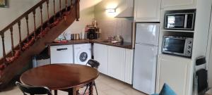 a small kitchen with a table and a refrigerator at Gîte Le Prieuré in Reugny