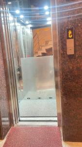 a glass elevator door in a building with a room at Hotel Blue Moon in Rishīkesh