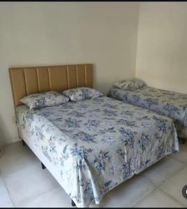 a bedroom with two beds with blue and white sheets at Casa Sol e mar Uruaú in Beberibe