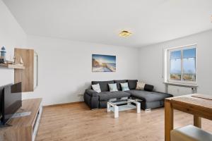 a living room with a couch and a table at Top Unterkunft direkt vor Leipzig in Schkeuditz