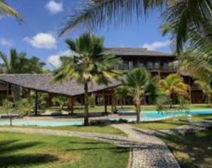 a resort with a swimming pool and palm trees at Casa Sol e mar Uruaú in Beberibe
