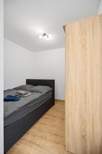 a bedroom with a bed and a wooden closet at Top Unterkunft direkt vor Leipzig in Schkeuditz