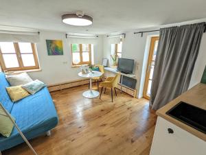 a living room with a blue couch and a table at Gemütliches, helles, voll ausgestattetes Apartment mit Terrasse in Waal