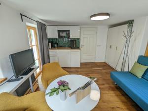a living room with a table and a blue couch at Gemütliches, helles, voll ausgestattetes Apartment mit Terrasse in Waal