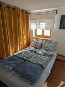 a bed in a bedroom with a window with curtains at Gemütliches, helles, voll ausgestattetes Apartment mit Terrasse in Waal