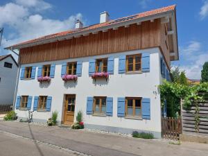 a white house with blue shutters on a street at Gemütliches, helles, voll ausgestattetes Apartment mit Terrasse in Waal