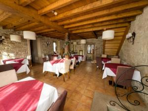 a restaurant with tables and chairs and wooden ceilings at Hotel Vila As Pedras in Roxos