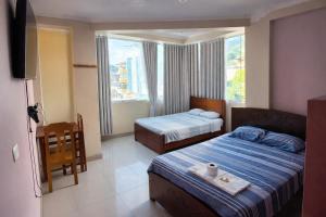 a hotel room with two beds and a window at HOSPEDAJE EL CANTARO II in Tingo María