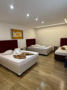 a room with three beds in a room at Hotel Leblon in Peruíbe +4 photos
