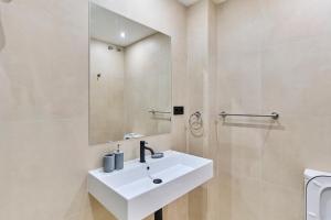 a bathroom with a white sink and a mirror at Sant Adrià Urban Suites by gaiarooms in Badalona