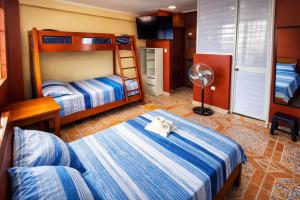 a bedroom with two bunk beds and a fan at HOSPEDAJE EL CANTARO II in Tingo María