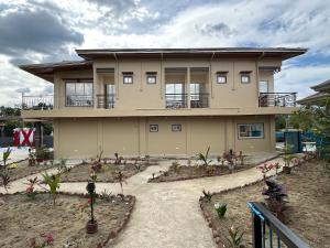 a large house with plants in front of it at Scarlett Near Mount Zion Laguit Padilla in Bugallon