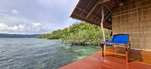 a blue chair sitting on the deck of a boat at Yonas Homestay - Raja Ampat in Besir +49 photos