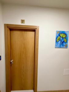 a wooden door in a room with a painting on the wall at Boutique Rooms Desi 1 in Pleven