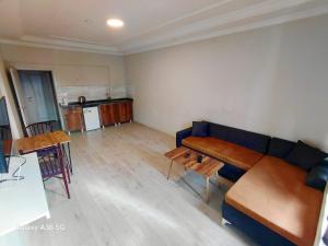 a living room with a blue couch and wooden tables at Esta123 in Kavaklıdere
