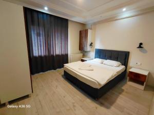 a bedroom with a bed and a large window at Esta123 in Kavaklıdere