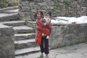 a woman holding a child on her shoulders at Hotel Tridev Manali in Manāli