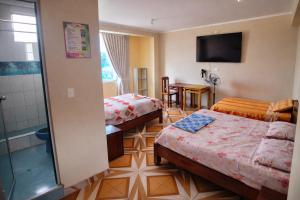 a hotel room with two beds and a shower at HOSPEDAJE EL CANTARO II in Tingo María