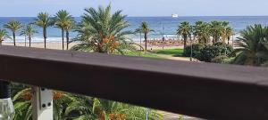 a view of a beach with palm trees and the ocean at Arrecife Beach in La Pineda