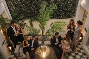 a group of people sitting around a table with a plant at Abalú Collection Hotel Boutique Gran Via in Madrid