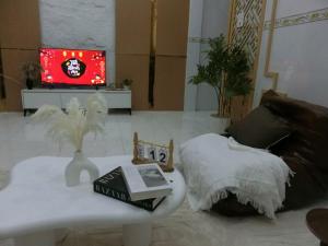 a living room with a coffee table and a tv at Mây homestay Phan Rang in Bắc Sớn