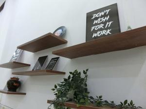 a shelf with a sign that says dont wish for it work at Mây homestay Phan Rang in Bắc Sớn