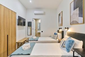 a hotel room with two beds and a table at Sant Adrià Urban Suites by gaiarooms in Badalona