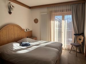 a bedroom with a bed and a large window at Hotel La Montanina in Livigno